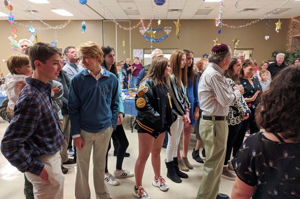group of teens and adults standing in social hall