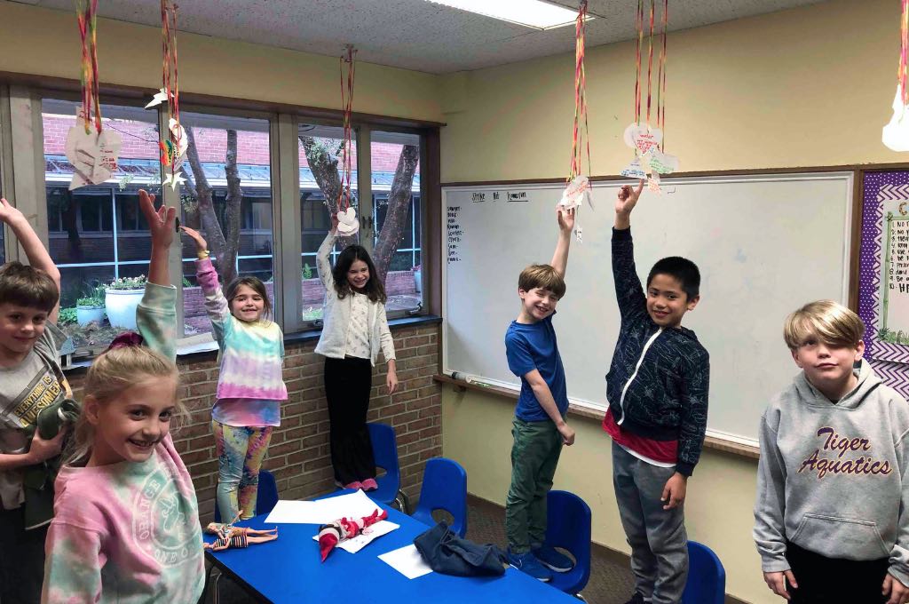 kids standing on chairs in a classroom