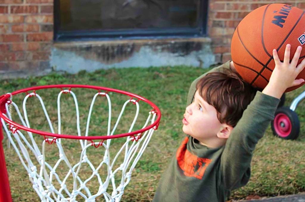 rayner center child dunking basketball in toy hoop