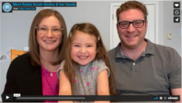 This is a screenshot of a video that shows Rabbi Sarah Smiley and Rabbi Josh Leighton with their young daughter in the middle of them.