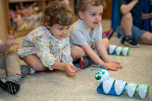 Two preschool children play with robots during STEM class.
